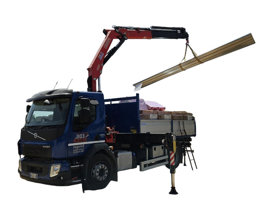 Camion con gru che scarica materiali edili in un cantiere della Trexenta